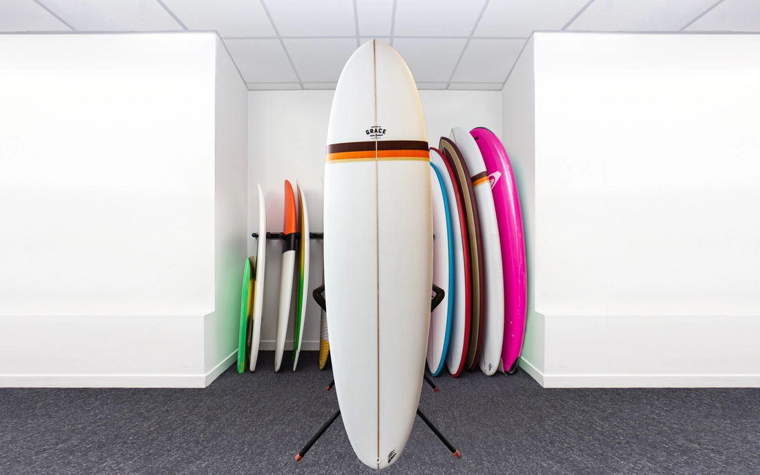 Hardtop Mini Malibu vor einer Reihe Surfboards