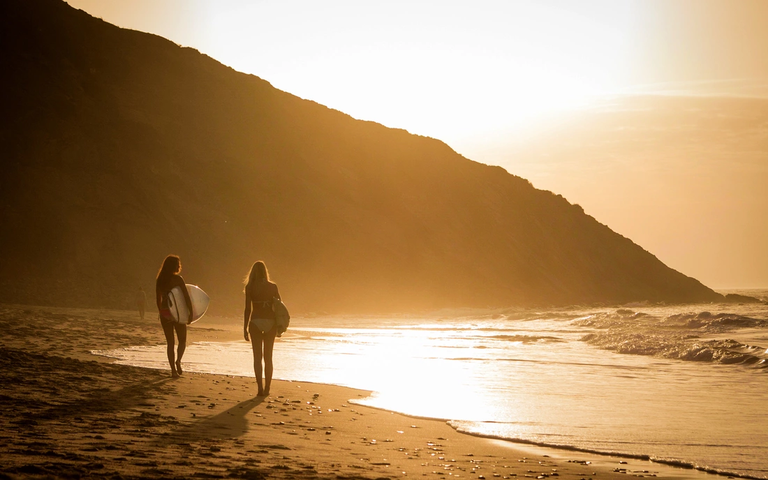 puresurfcamps-surflodge-portugal-surfer-streand-sonnenuntergang-steilküste-klippe