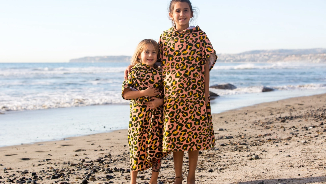 Kinder im Surf Poncho am Strand