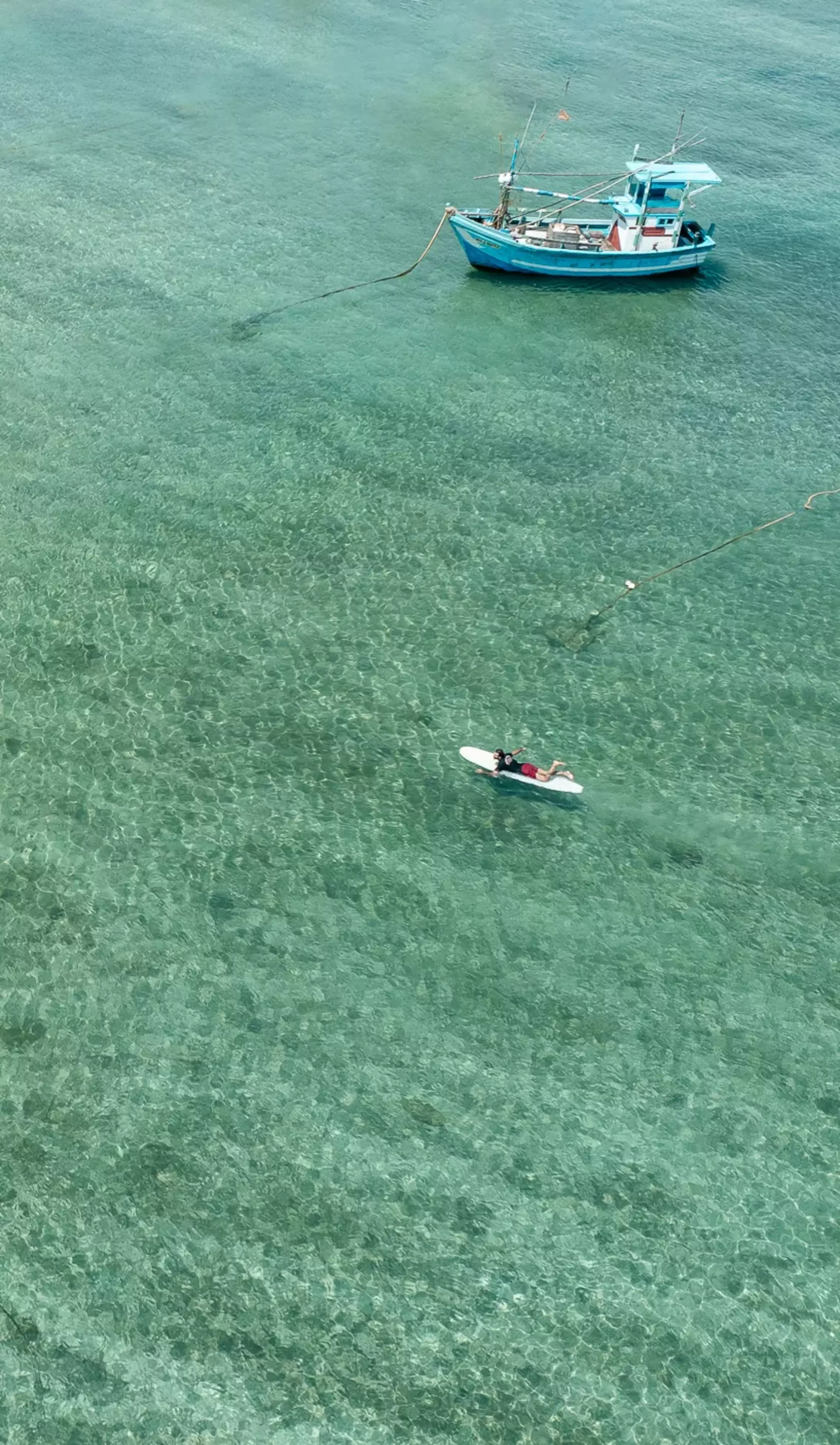surfer paddelt durch fischkutter