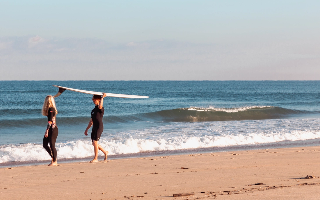 Surfer im Neoprenanzug am Strand