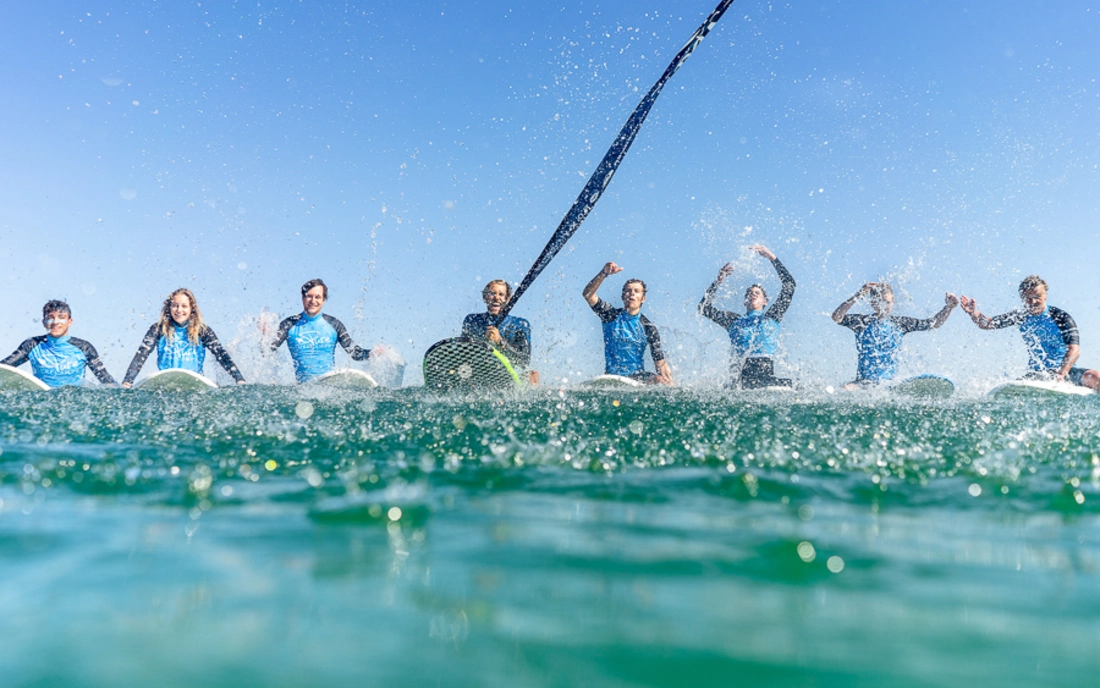 Surflehrer mit Surfkurs auf Surfbrettern im Wasser