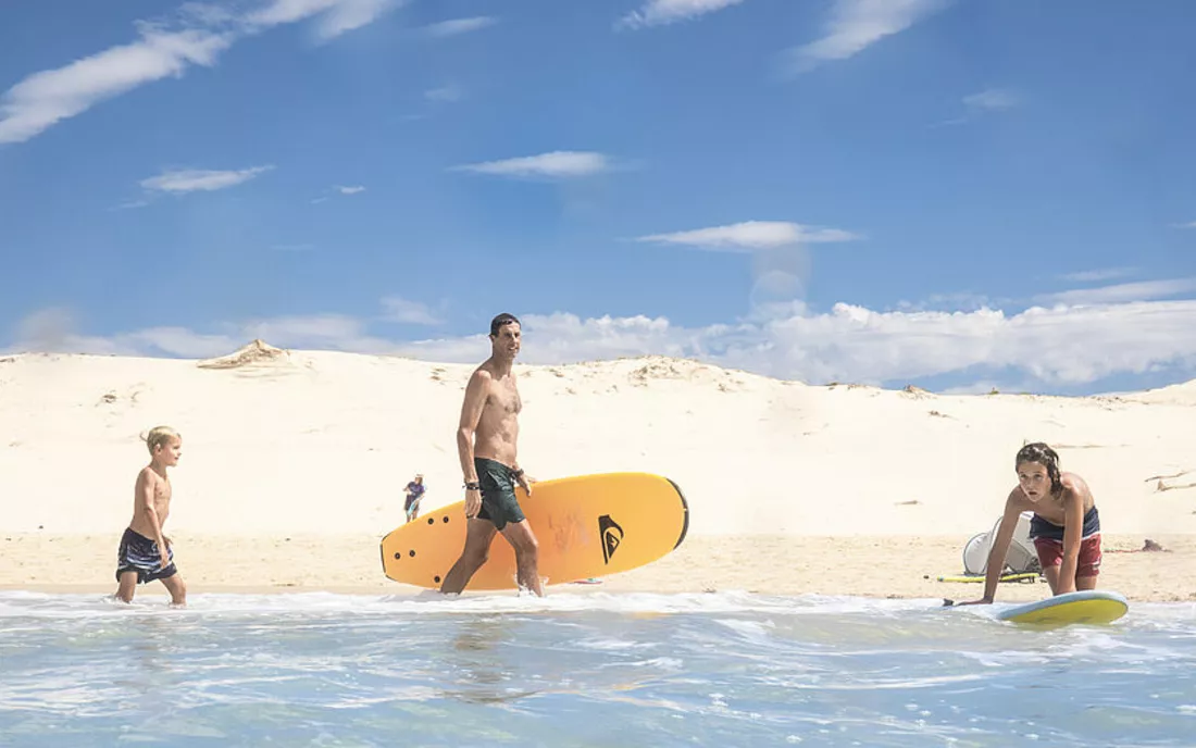 Familie im Surfkurs beim surfen lernen