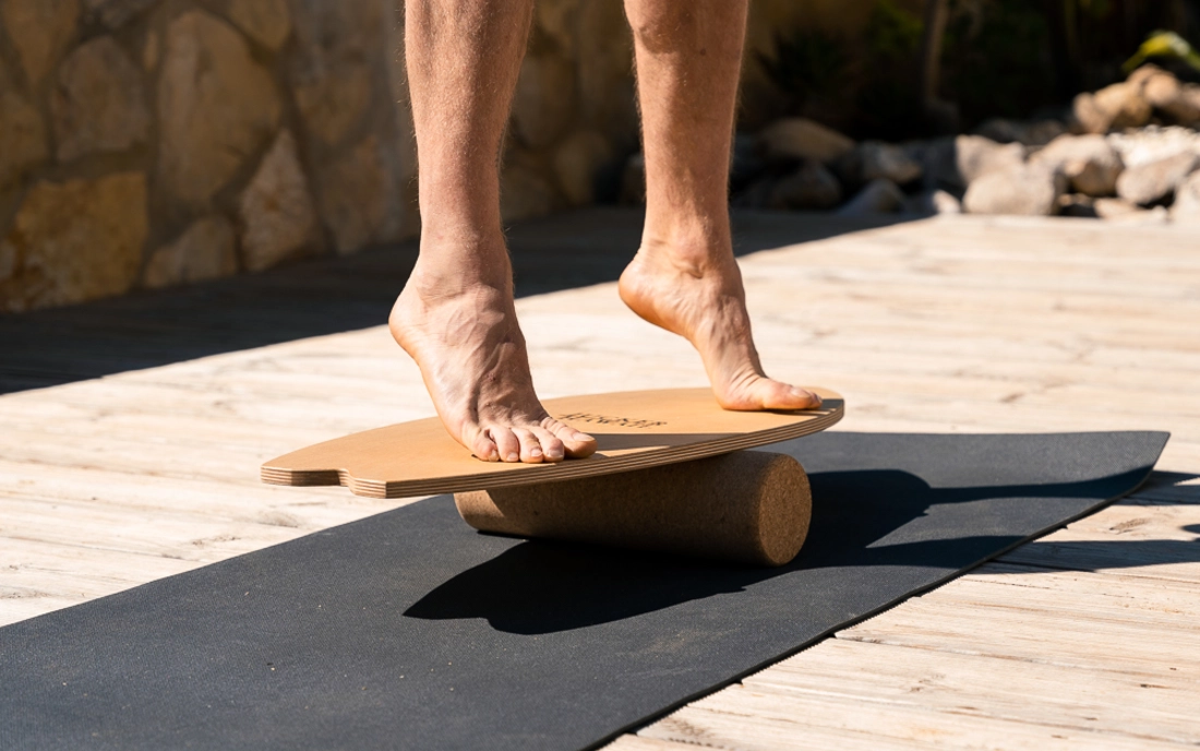 Mann auf Zehenspitzen auf Balance Board aus Holz