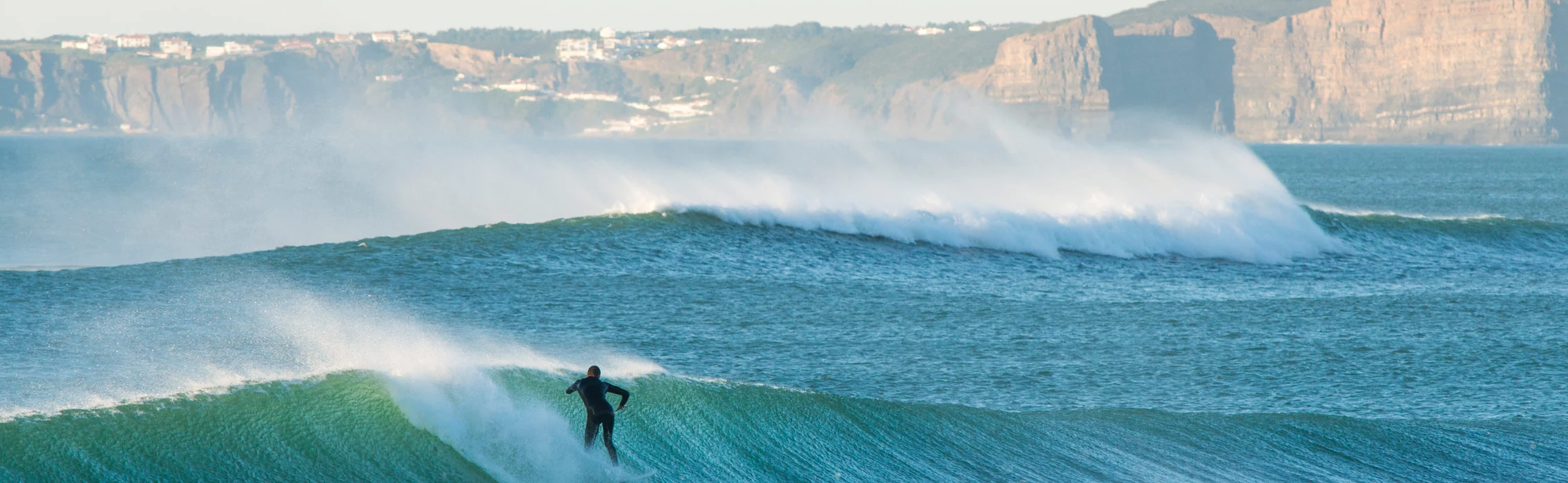 Surfer surft brechende Welle in Portugal