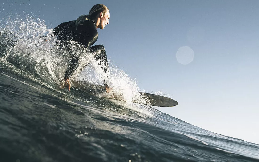 Surfer auf Surfbrett am Surfen