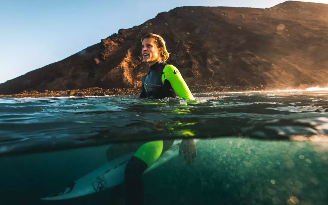 surfing sitting on his surfboard in the water