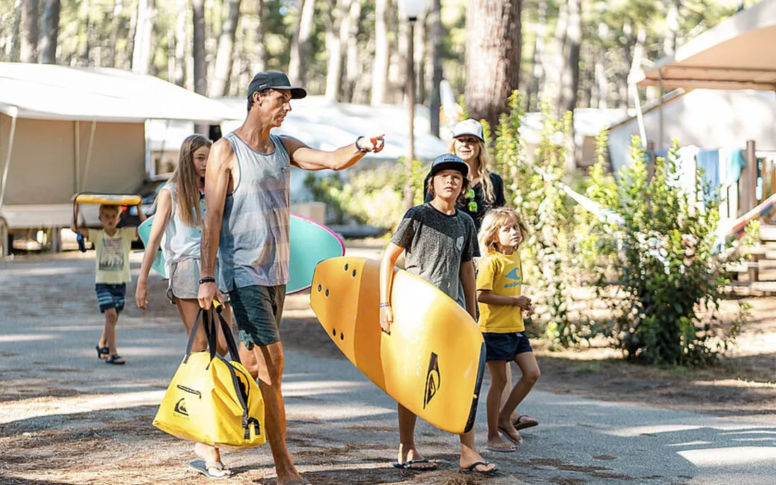 Familie auf dem Weg zum Surfkurs