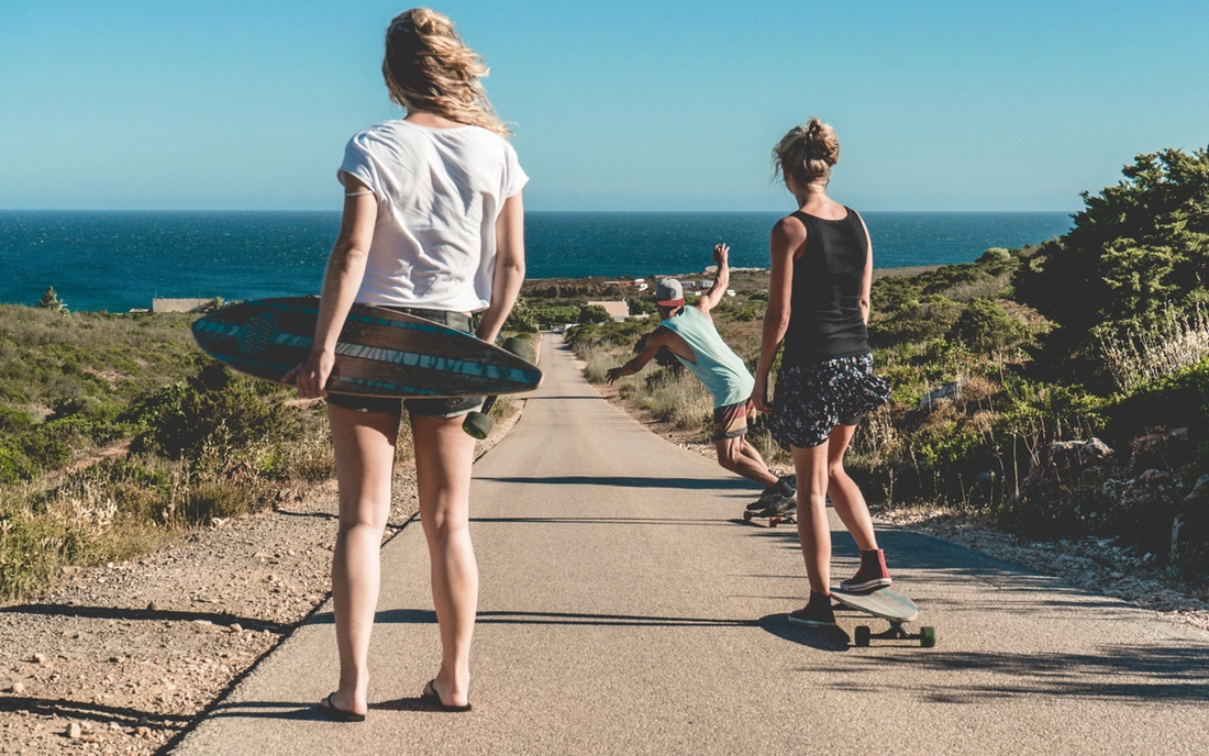 Cruising to the beach on longboards and skateboards