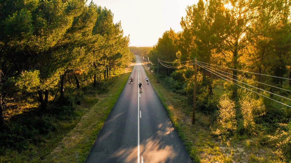 Longboarder cruisen die Straße entlang