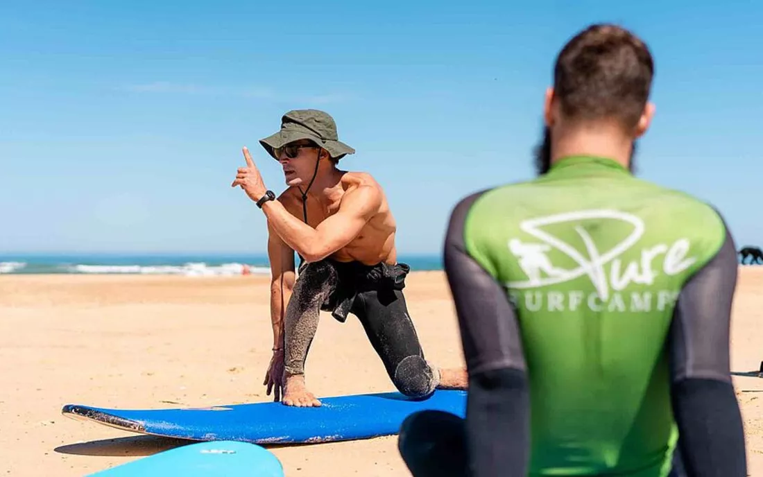 Surfschule mit Surflehrer beim Surfunterricht am Strand