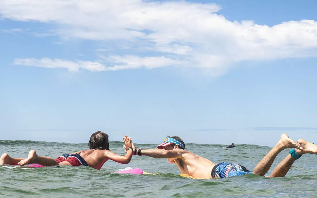 Vater und Sohn im Surfkurs beim Surfen lernen