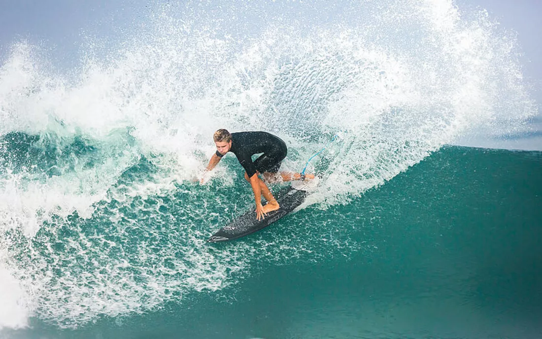 Surfer beim Surfen im Surfmanöver