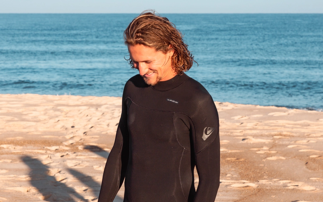 Surfer im Neoprenanzug am Strand