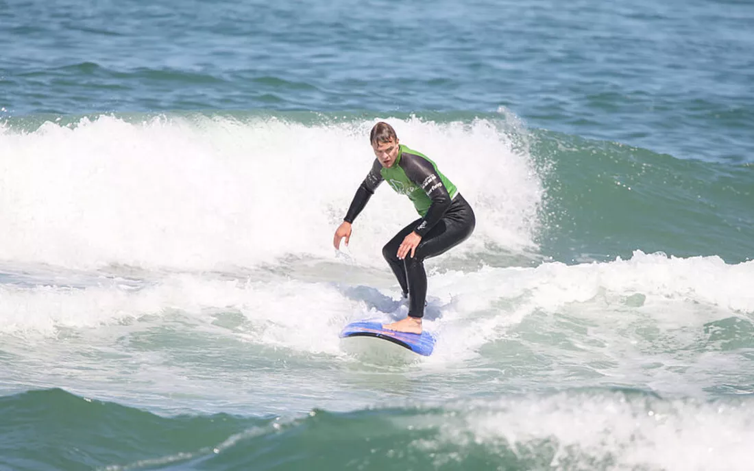 Surfer beim Surfen Lernen im Surfkurs