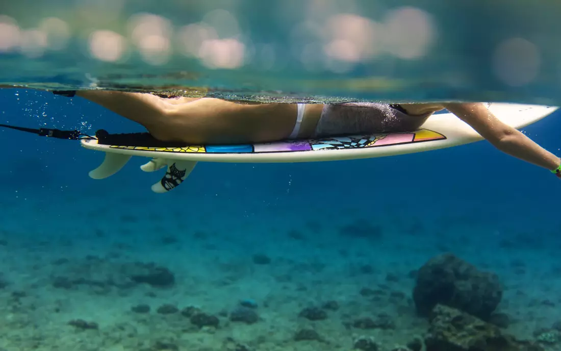 girl on surfboard under water