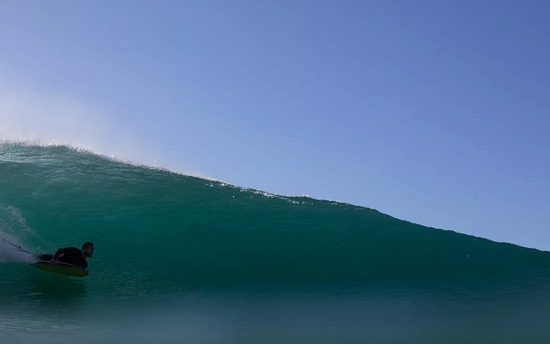 Surfer auf Bodyboard Surfbrett am Surfen