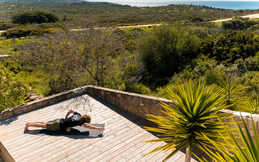 Mann beim Surfworkout auf Balance Board aus Holz mit Korkrolle