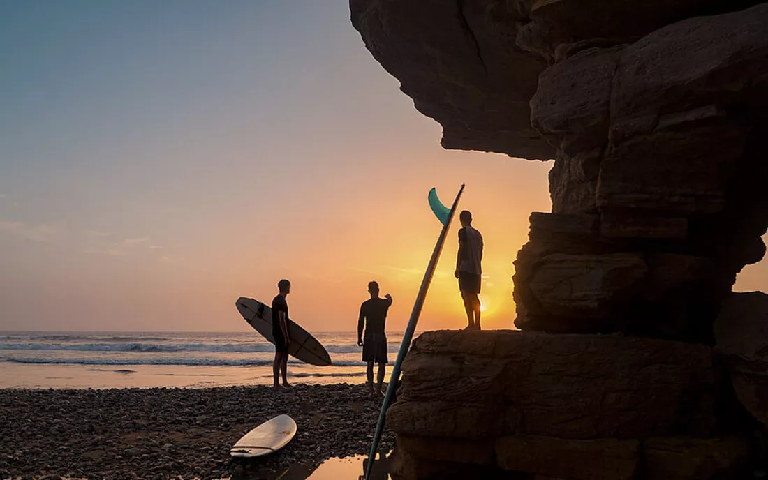 Surfer mit Surfboards am Strand in Marokko