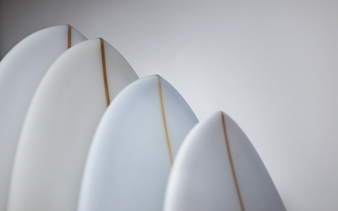 Weiße Surfbretter mit unterschiedlichen Shapes aneinander gereiht