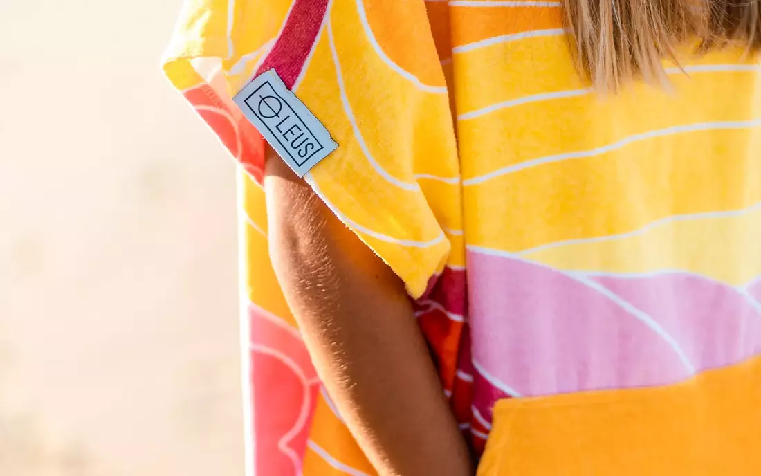 Detailaufnahme eines Surf Poncho Labels an Surferin