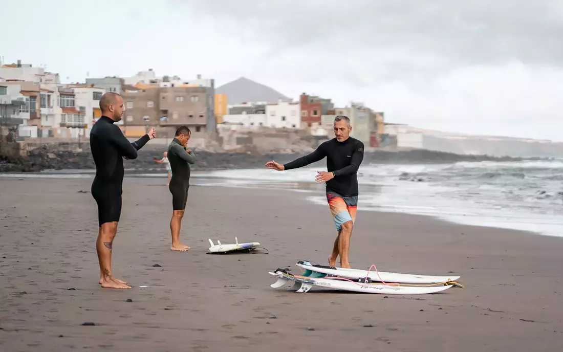 [Translate to English:] Surfer beim Warm Up am Strand