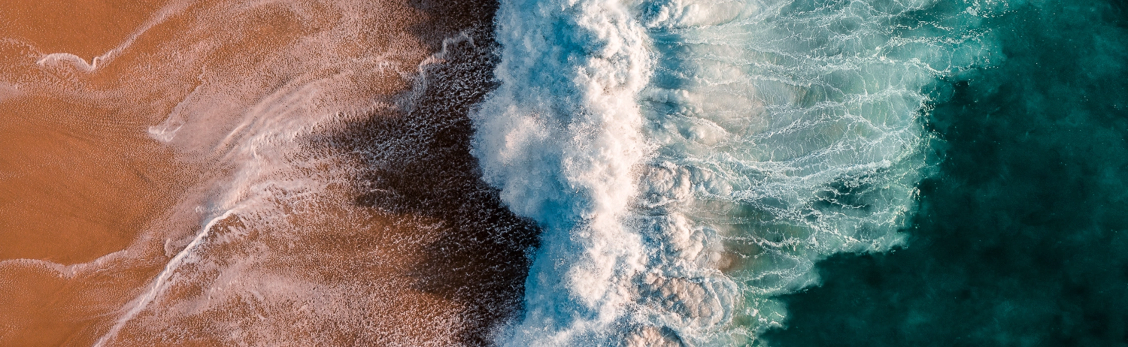 Auf den Strand brechende Welle von oben