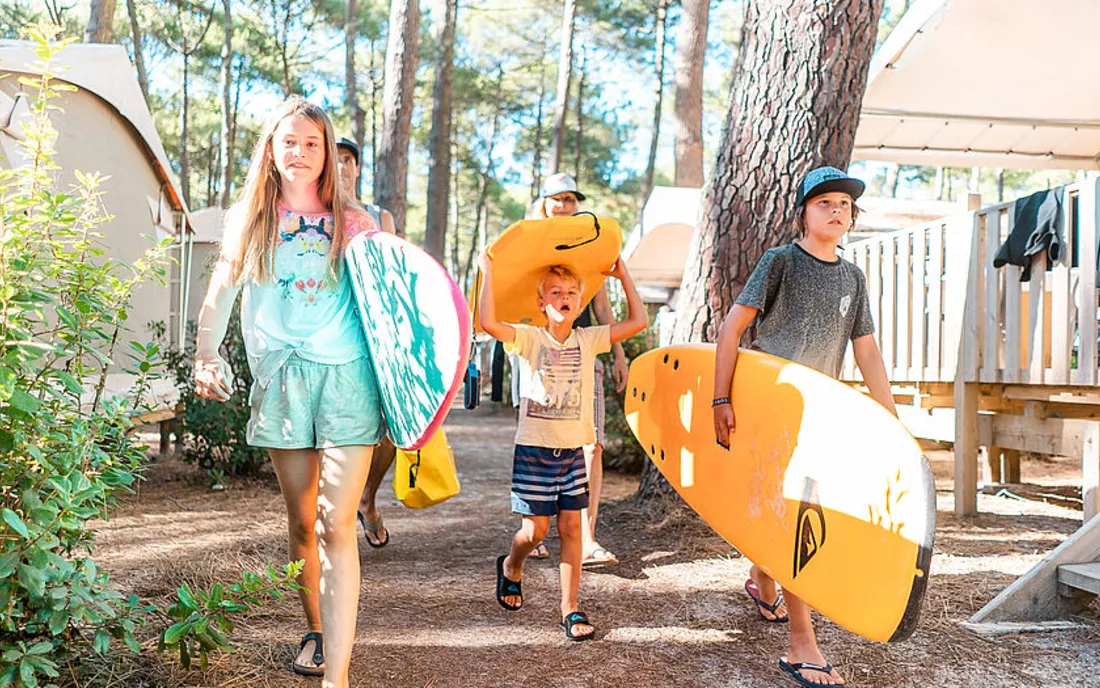 Kinder mit Surfbrettern im Familien Surfcamp