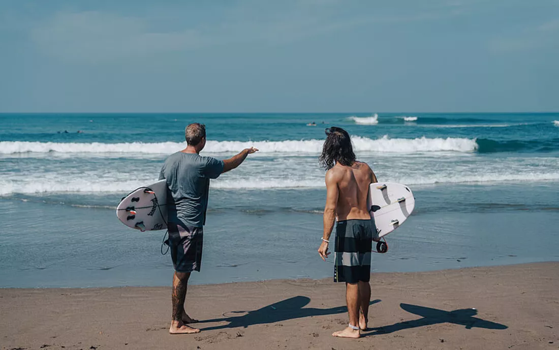 Surfer mit Surfbrett am Strand