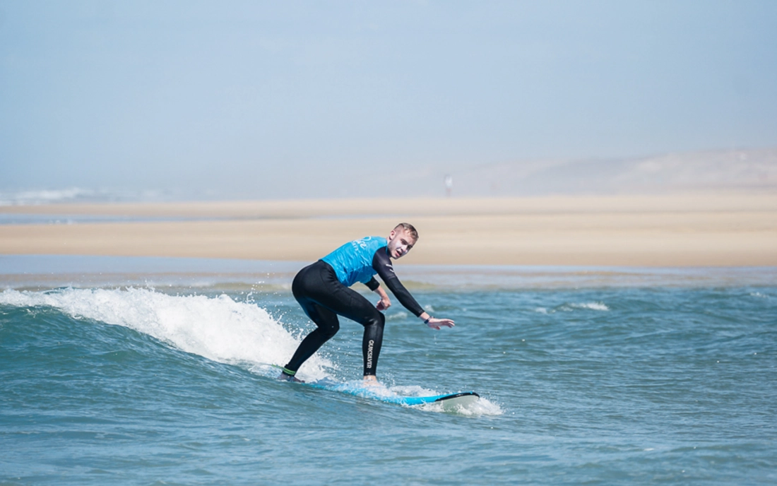 Surfkursschüler surft eine Welle