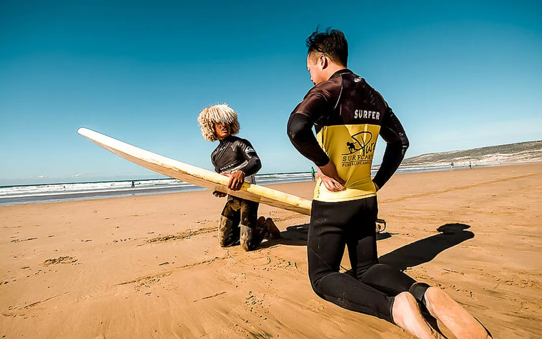 Surfschueler beim Surfen lernen mit Surflehrer