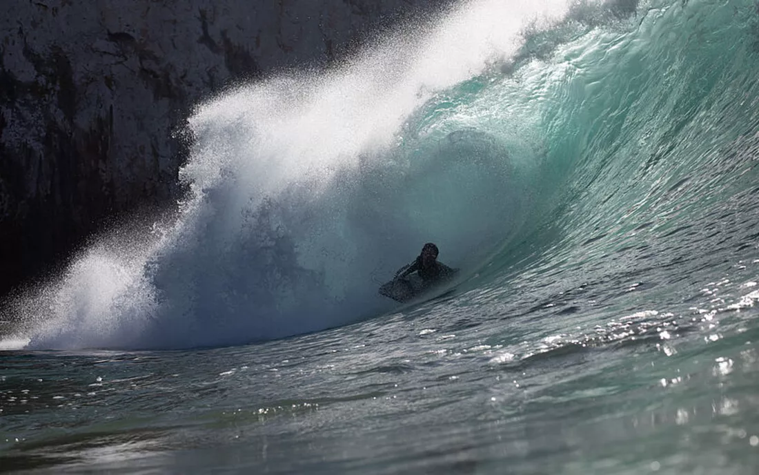 Surfer auf Bodyboard Surfbrett in Barrel