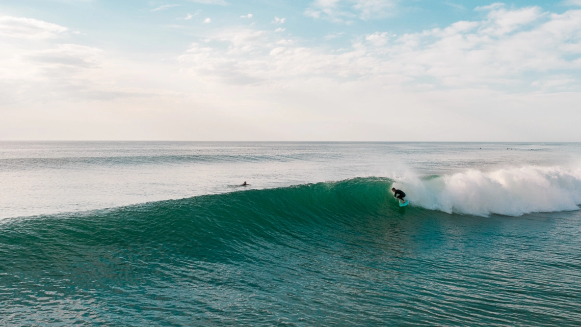 Surfer surft Welle am Hausstrand des Surfcamp Seignosse