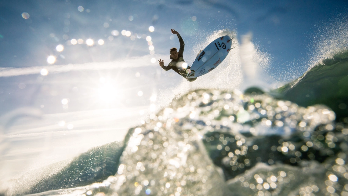 leon glatzer fliegt durch die sonne beim wellenreiten während dem pure surf team trip