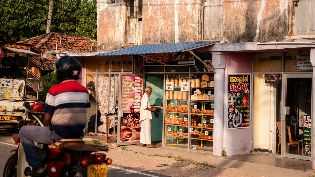 Rollerfahrer und Laden in Sri Lanka