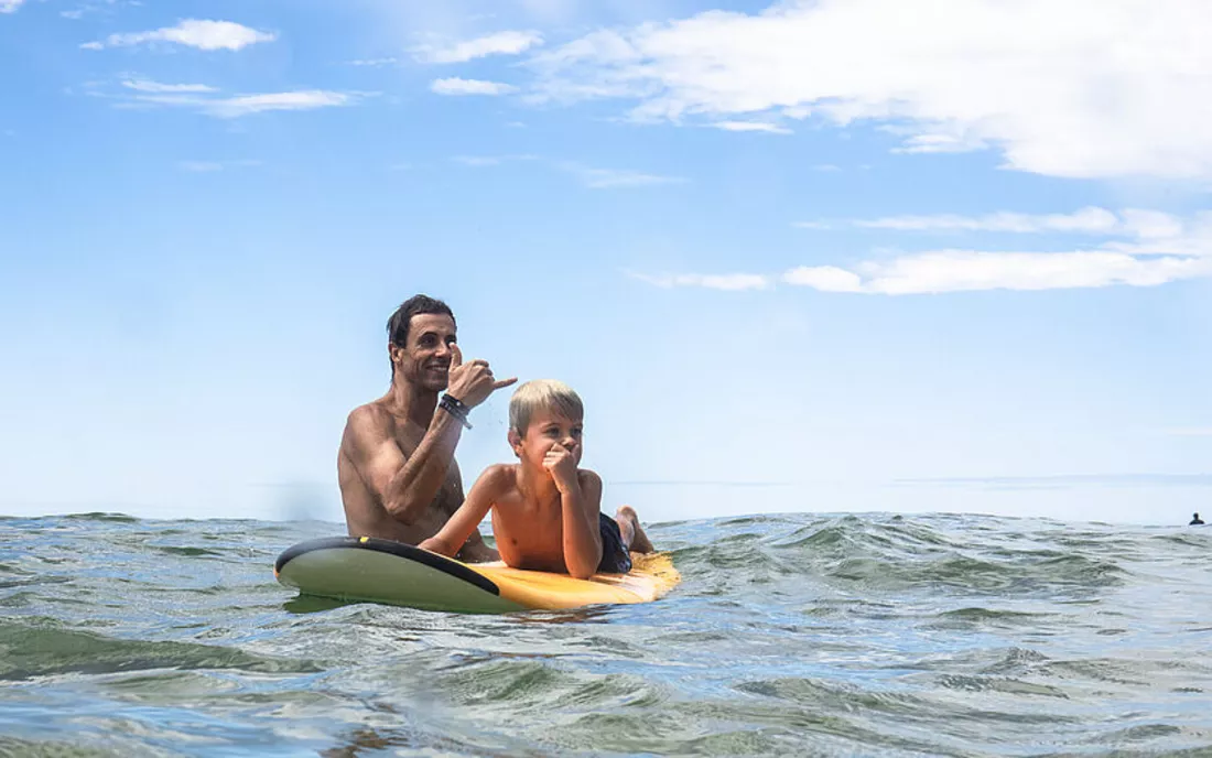 Vater und Sohn im Surfkurs beim Surfen lernen