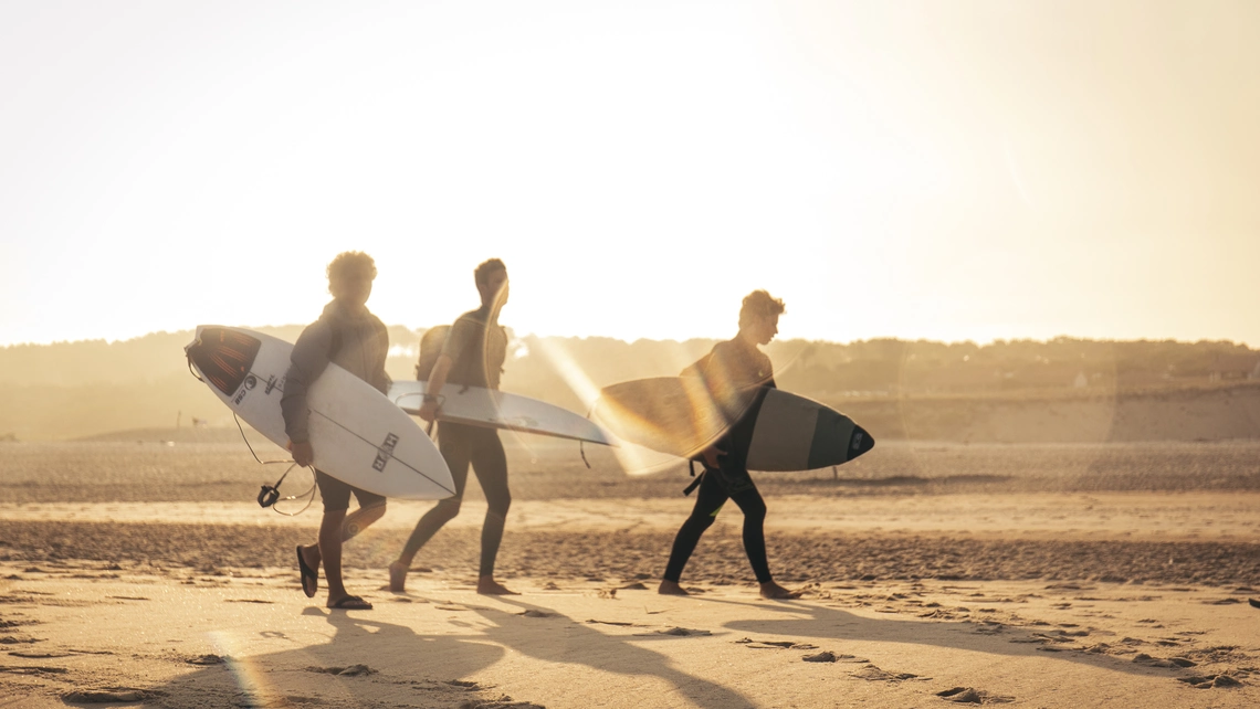 Surfer laufen über den Strand