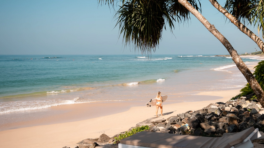 Surferin Am strand unter Palmen