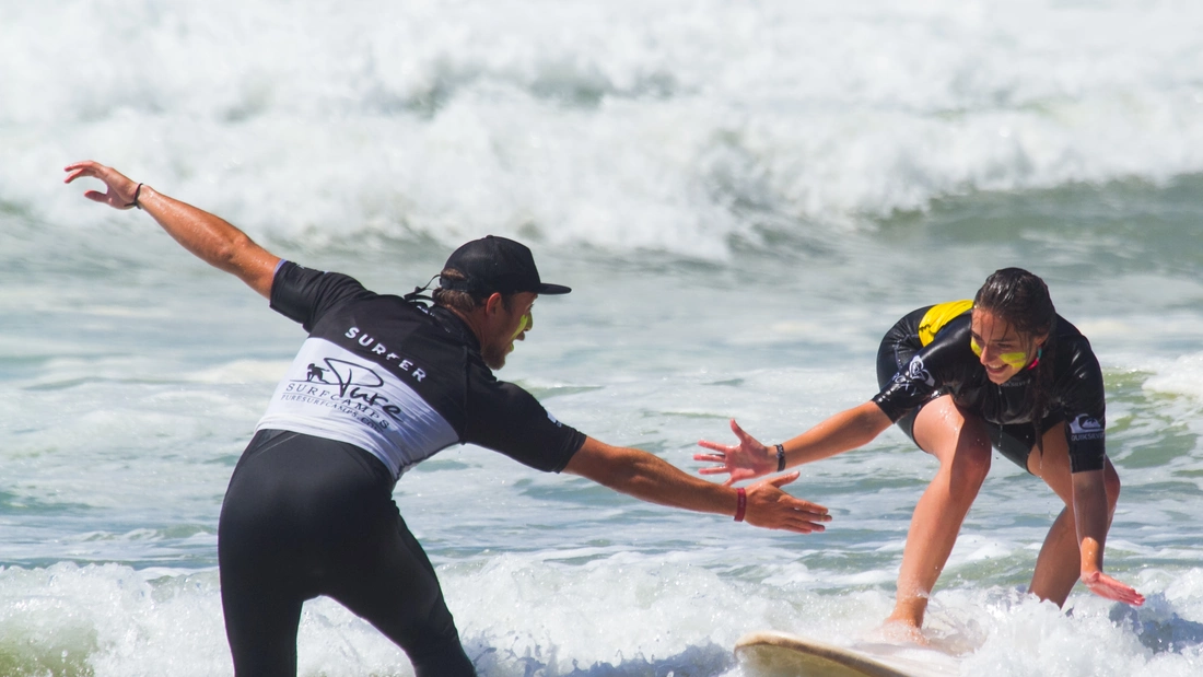 surf student and surf instructor in the water