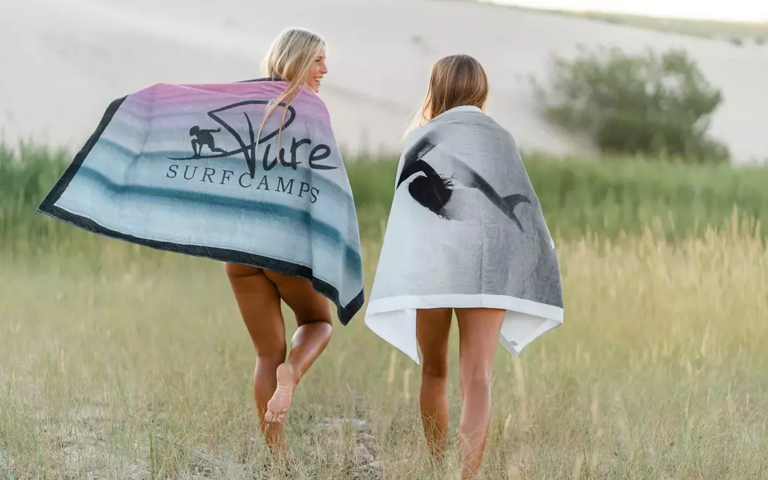 frauen in puresurfcamps handtuechern auf wiese