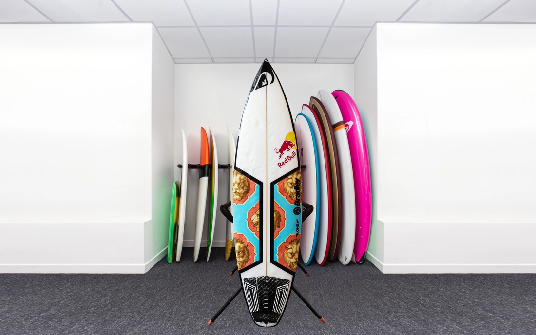 Buntes Shortboard Surfbrett vor einer Reihe Surfboards