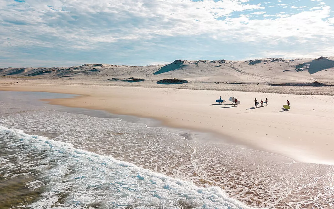 Surfer mit Surfbrett am Strand in Frankreich