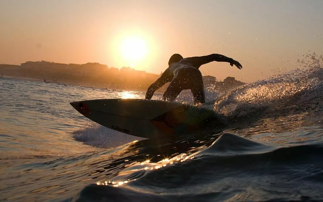 Surfer beim Surfen zum Sonnenuntergang