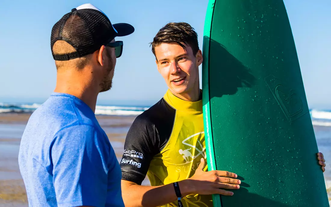 surf student and surf instructor at the beach