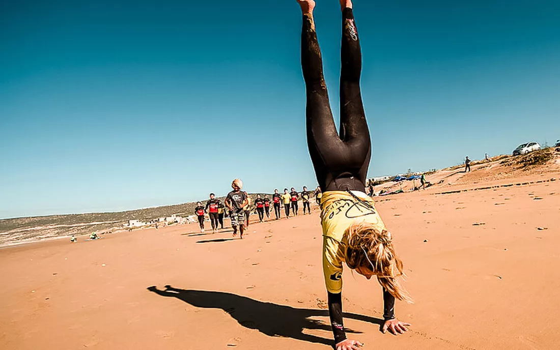 Surfschule beim Aufwärmen am Strand