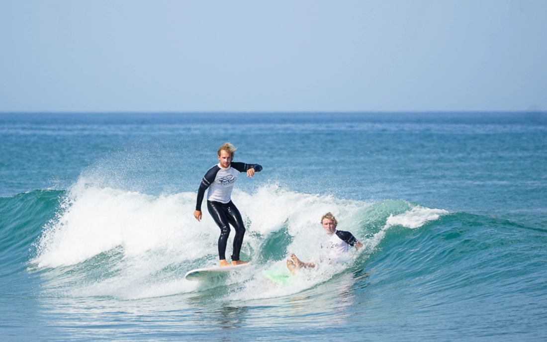 Surflehrer surfen gemeinsam eine Welle